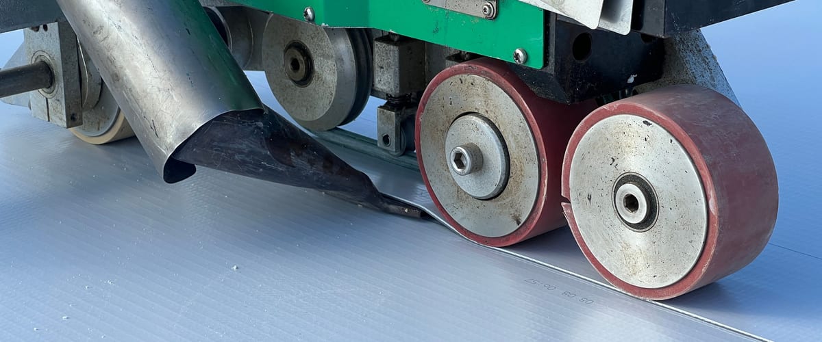 Soudure à l'air chaud d'une membrane PVC par un automate de soudure, sur une toiture-terrasse